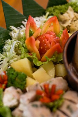 Doğal olarak muz yaprakları üzerinde patates küpleri, marul, lahana ve domates garnitürlü otantik Endonezya buğulama sebze yemeği. Yerel sağlıklı mutfağı göstermek için mükemmel.