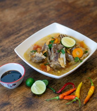 Sop iga, Endonezya sığır eti çorbası sebzeli ve limonlu köy ahşap masada servis ediliyor.