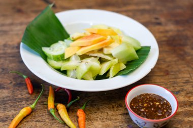 Endonezya meyve salatası ya da ahşap masada muz yaprağı olan beyaz bir tabakta rujak.
