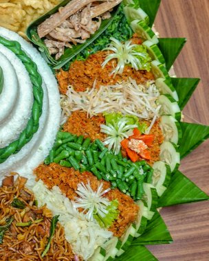 Endonezya usulü pirinç tabağı urap sebzeler, fasulye filizi, uzun fasulyeler, rendelenmiş hindistan cevizi sambali, erişte ve muz yaprakları üzerine güzelce yerleştirilmiş mezeler. Cava yemekleri Endonezya 'da minnettarlığı ve şenliği sembolize eder.