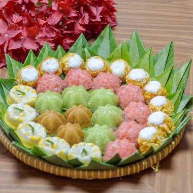 Çeşitli geleneksel Endonezya tatlıları muz yaprakları üzerinde güzelce düzenlenmiş. Pirinç unundan yapılmış otantik Asya tatlı çeşitleri, yazı işleri ve mutfak tasarımı projeleri için mükemmel..