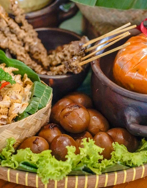 Saten, haşlanmış yumurta, doğranmış tavuk ve muz yaprağı ve kil kaselerinde köri sosu ile geleneksel Endonezya yemeği seti. Yemek blogları, restoran menüleri ve geleneksel yemek koleksiyonları için ideal.