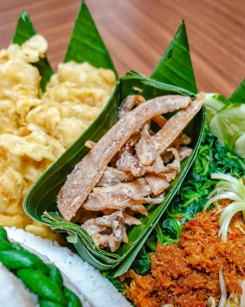 Muz yaprağında servis edilen tuzlanmış pirzola ya da gereh layur 'un yakın çekimi. Köy dokusuna sahip otantik Endonezya geleneksel mezesi