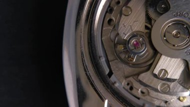 Mekanik bir otomatik saatin, denge çarkı, mücevher ve teçhizat montajının içerisindeki makro görüntüleri. Yüksek detaylı mühendislik ve işçilik içeriği.
