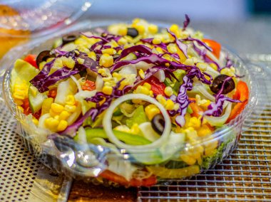 Mısır, kırmızı lahana, soğan, zeytin ve marullu taze sebze salatası. Sağlıklı yemek, vejetaryen yemeği, diyet ve temiz yeme konsepti