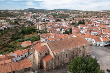 Portekiz 'de mavi bir gökyüzü altında geleneksel mimari merkezi ile çevrili olan kilise binasının heybetli olduğu Freixo de Espada a Cinta köyünün panoramik manzarası