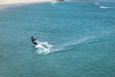 Rüzgarın gücü ve tam manevra yapan bir uçurtmacı denizin yüzeyinde iz bırakıyor.