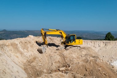 Kazıcı tarımsal sulama için su depolamak için bir gölet veya baraj inşaatında çalışıyor.