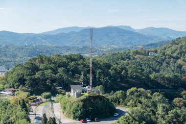 İspanya 'da ormanlık bir dağ manzarası olan bir otoparkın ortasında birbirine dolanmış metal şanzıman kulesi.