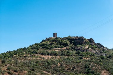 Penas Roias Tapınağı 'nın kalesi Mogadouro' da berrak bir gökyüzünün altındaki ormanlık yamaçta.