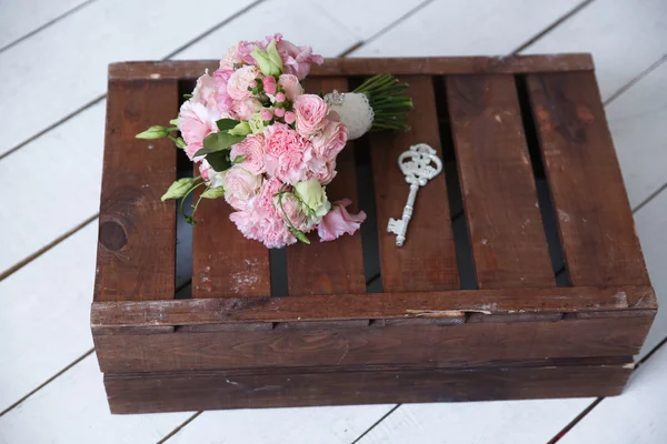 Bouqet de casamento e uma chave na caixa de madeira — Fotografia de Stock