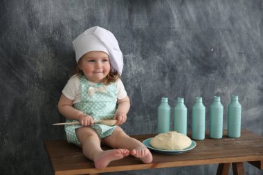Hamur, siyah bord arka plan üzerine bir tabak ile küçük baker bebek kız