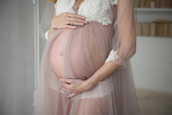 여 자가 그녀의 손으로 그녀의 임신 배꼽을 들고 — 스톡 사진