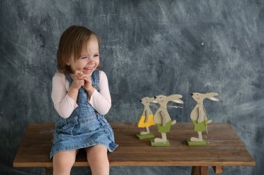 Küçük kız siyah yazı duvar arka masada oturan