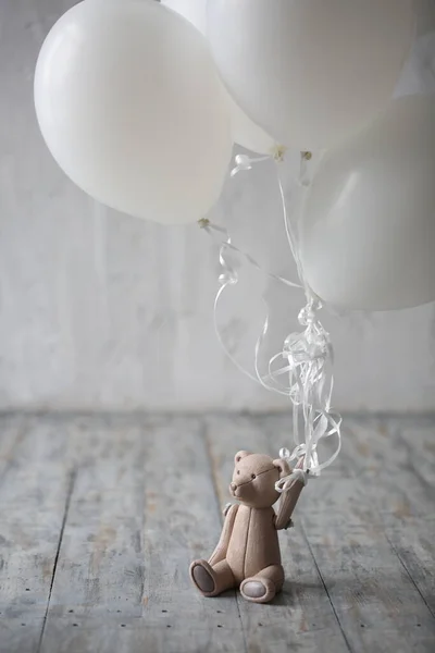 cute lonely teddy bear holding balloons