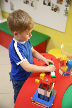 Çocuk bir inşaatçıdan ev inşa ediyor.