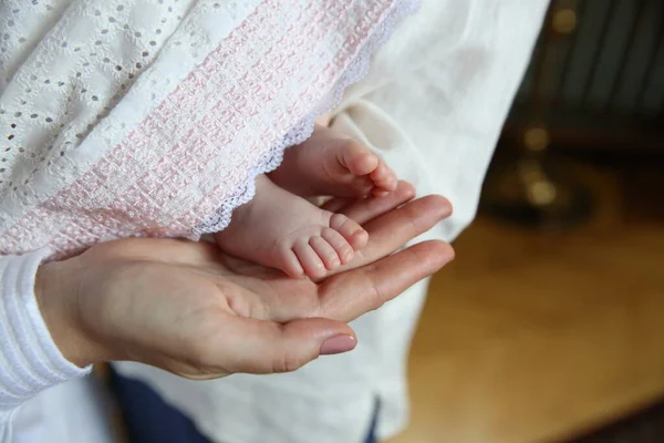 ritual of baptism. little feet in the hands of parents