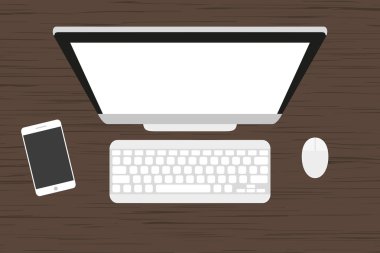 Ahşap bir masa işyerinde. Monitör, klavye, bilgisayar fare ve akıllı telefon