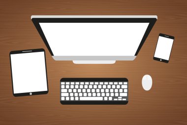 Ahşap bir masa işyerinde. Monitör, klavye, bilgisayar faresi, tablet ve akıllı telefon