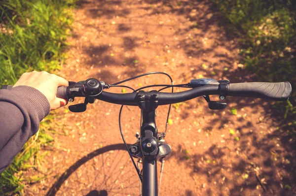 hand on bicycle handlebar on bike lane in nature