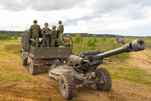 Portugalilaiset sotilaat seisovat armeijan kuorma-autossa kenttähaupitsin kanssa. — kuvapankkivalokuva