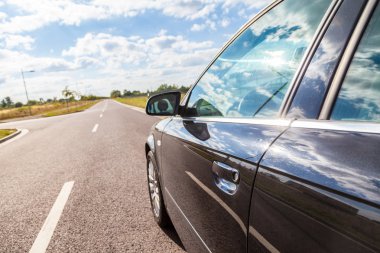 geniş bir cadde tarafında siyah bir araba