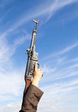 mavi arka plan üzerinde bir elinde silah