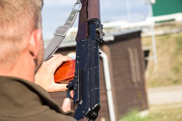 Um homem carrega sua arma — Fotografia de Stock