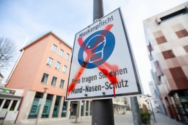 Alman mesajlı bir Alman şehrinde bilgi imzası. Bir ayaklanma onu kırmızı bir x maskenpflicht, Bitte tragen Sie einen Mund-Nasen-Schutz ile işaretliyor. Maske zorunludur, lütfen ağız ve burun koruması takın..