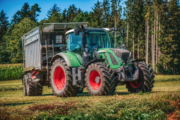 Green Tractor Loading Wagon Meadow — Stock Photo, Image