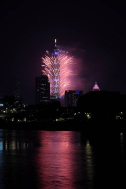 Tayvan 'da havai fişek gösterisi. Havai fişek patlaması Taipei 101 binasını aydınlatıyor..