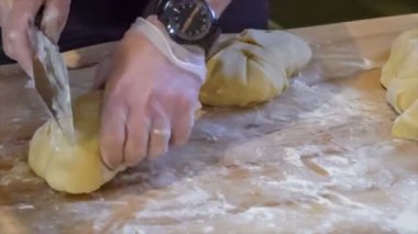 Aşçı hamuru fırın bıçağıyla kesiyor.