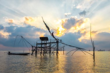Net siluet büyük balık tuzakları ve balıkçı şafak.
