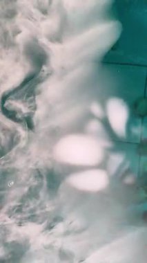 Zarif Koi Balığı, Göksel Beyaz Duman ve Mavi Yansımalarla Açık Havuzda Gizemli Yüzüyor.