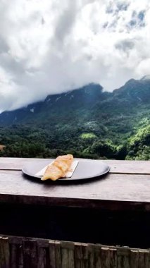 Güzel Tropikal Dağ Manzaralı Açık Yemek Konseptine karşı Yoğunlaştırılmış Süt ile Lezzetli Tatlı Roti Pankeki.