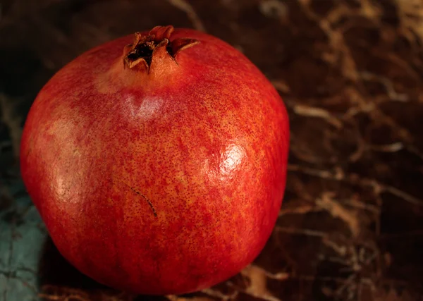 Red ripe pomegranate fruit on a stone — Stock Photo, Image