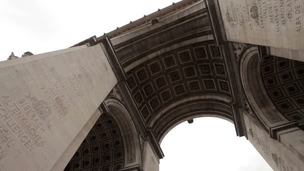 Arc De Triomphe op een bewolkte dag. Langzame pan onder de boog. — Stockvideo