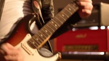 Gitarist. Elektro gitar çalmak başlayan bir erkek eli yakın çekim.