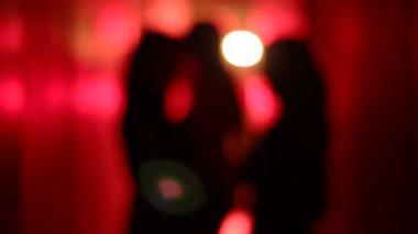 Bulanık, kırmızı koridorda kaldırdı elleriyle dans üç seksi kadın silüeti.