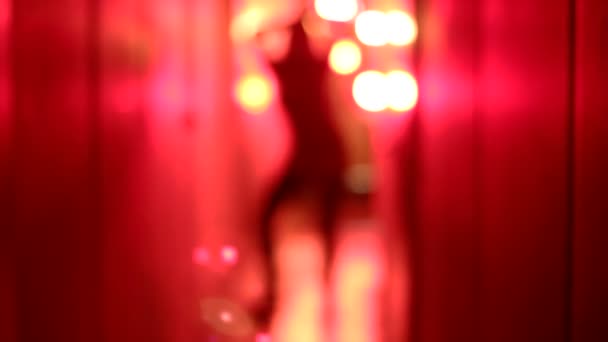 Silhouette di una donna sexy con tacchi alti che balla in un corridoio rosso sfocato . — Video Stock