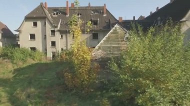 Kömür madenciliği kasaba Gladbeck terk edilmiş bir mahallenin andan, Almanya, düşük irtifa uçuş, evlerin ve coppice bir dizi önünde soldan sağa yakın izleme atış.