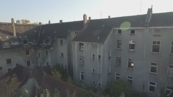 Antenne eines verlassenen Viertels in der Bergbaustadt Gladbeck, Deutschland, mittlere Kamerafahrt von rechts nach links vor einer schäbigen Häuserzeile, die langsam von links nach rechts schwenkt, mit Linsenblitz. — Stockvideo