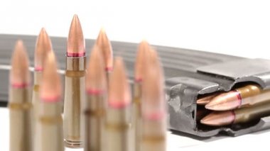 Ak-47 mühimmatı. Arkada yatan tam bir dergiden ön taraftaki bir avuç dik mermiye defokus.