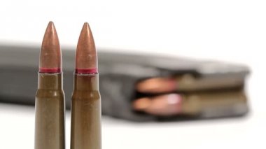 Ak-47 mühimmatı. Öndeki iki dik mermiden arkadaki tam dolu bir dergiye defokus.