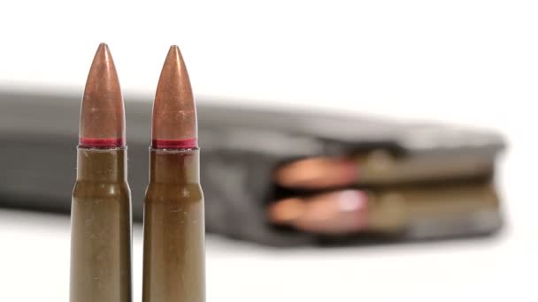 AK-47 ammunition. Defocus från två av upprätt kulor i fronten till en liggande full tidning i ryggen. — Stockvideo