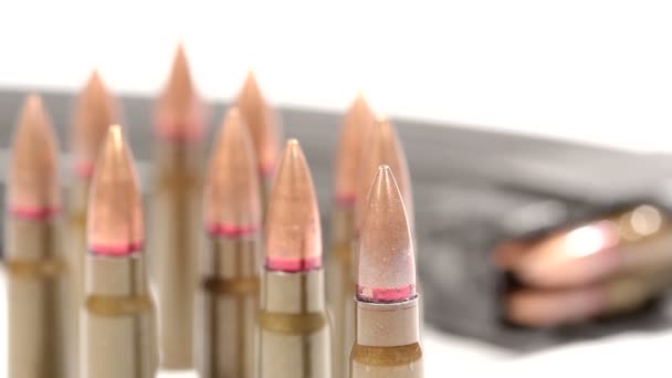 Ak-47 Munition. Defokussierung von einem Haufen aufrechter Kugeln vorne auf ein liegendes, volles Magazin hinten. — Stockvideo