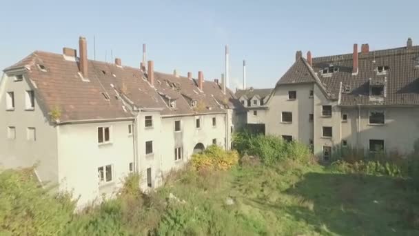Vue aérienne d'un quartier abandonné dans la ville minière de Gladbeck, en Allemagne, ascension lente au-dessus d'un pré et de maisons minables se terminant sur une centrale en exploitation .