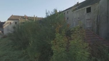 Kömür-Maden kasaba Gladbeck, Almanya, yavaş çıkış ileri eski püskü büyümüş üste evlerin önünde terk edilmiş bir dönemin hava, soldan sağa ve objektif bir pan-shot ile biten flare.