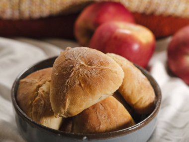 autumn seasonal baking, apple pie pastries, traditional ukrainian bakery, cozy atmosphere with apples, cinnamon sticks, white linen textile, warm tones knitwear