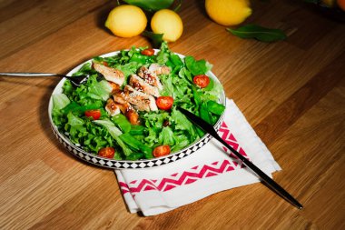 Kızarmış tavuk salatası, yeşil marul, ızgara et, yeşil bezelye, domates, limon, taze ve sağlıklı Akdeniz usulü yemek.